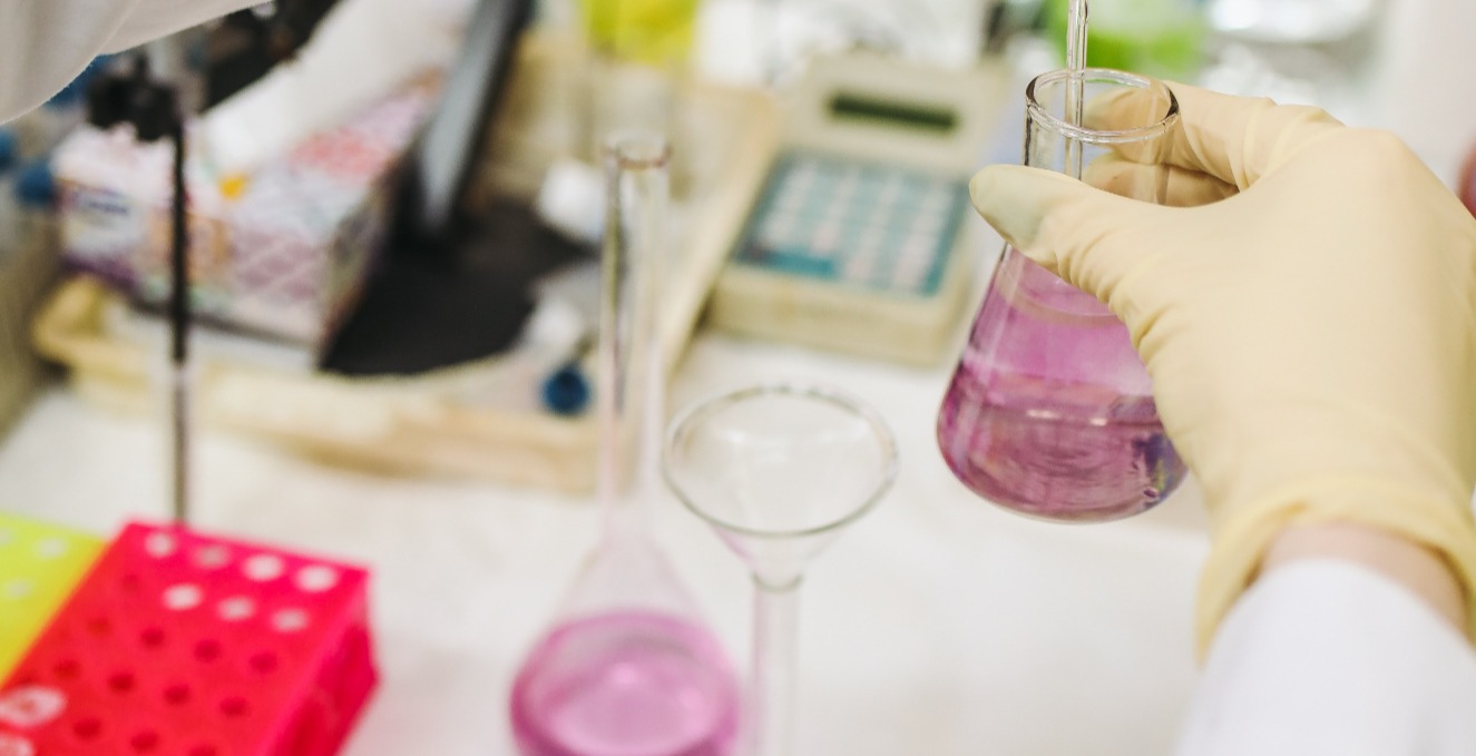 researcher working with pink liquid